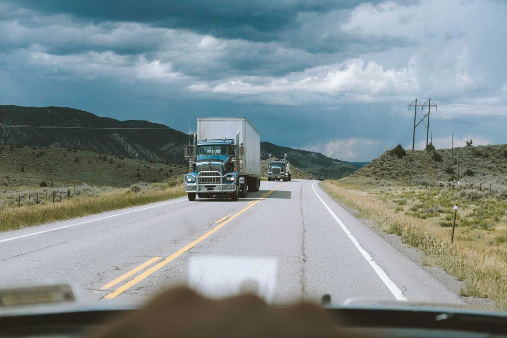 driving on rural road with two trucks oncoming