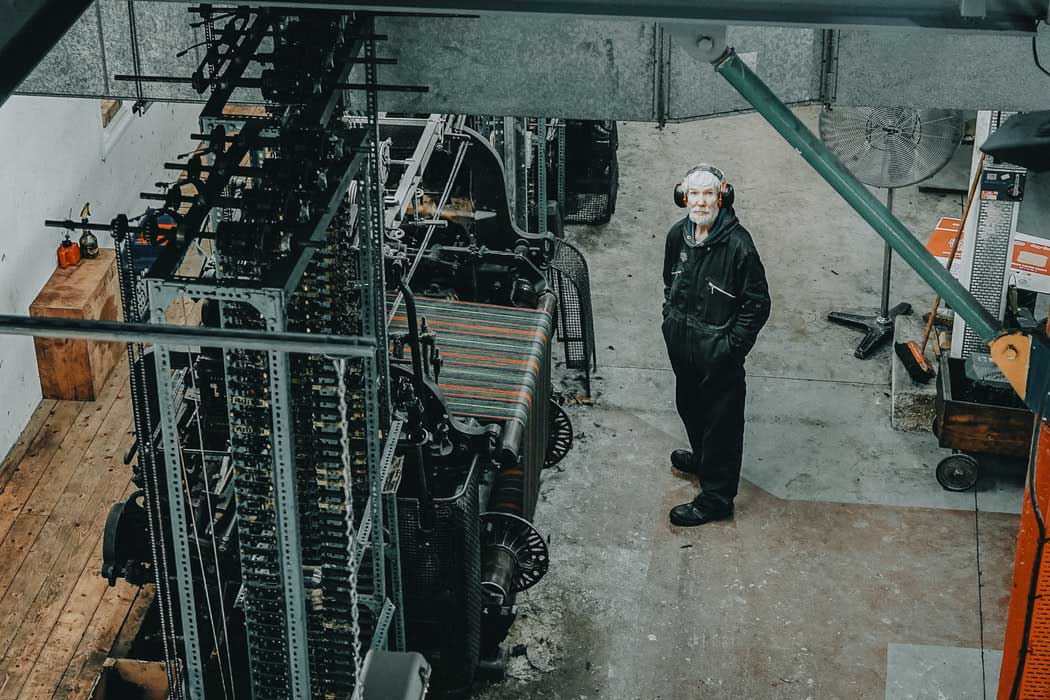 older man in factory wearing headphones